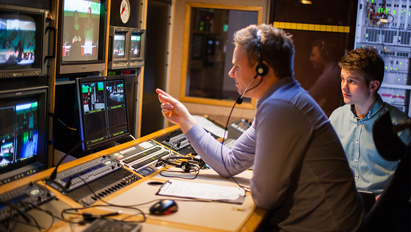 Teknikere styrer produksjonen fra innsiden av TV-bussen.