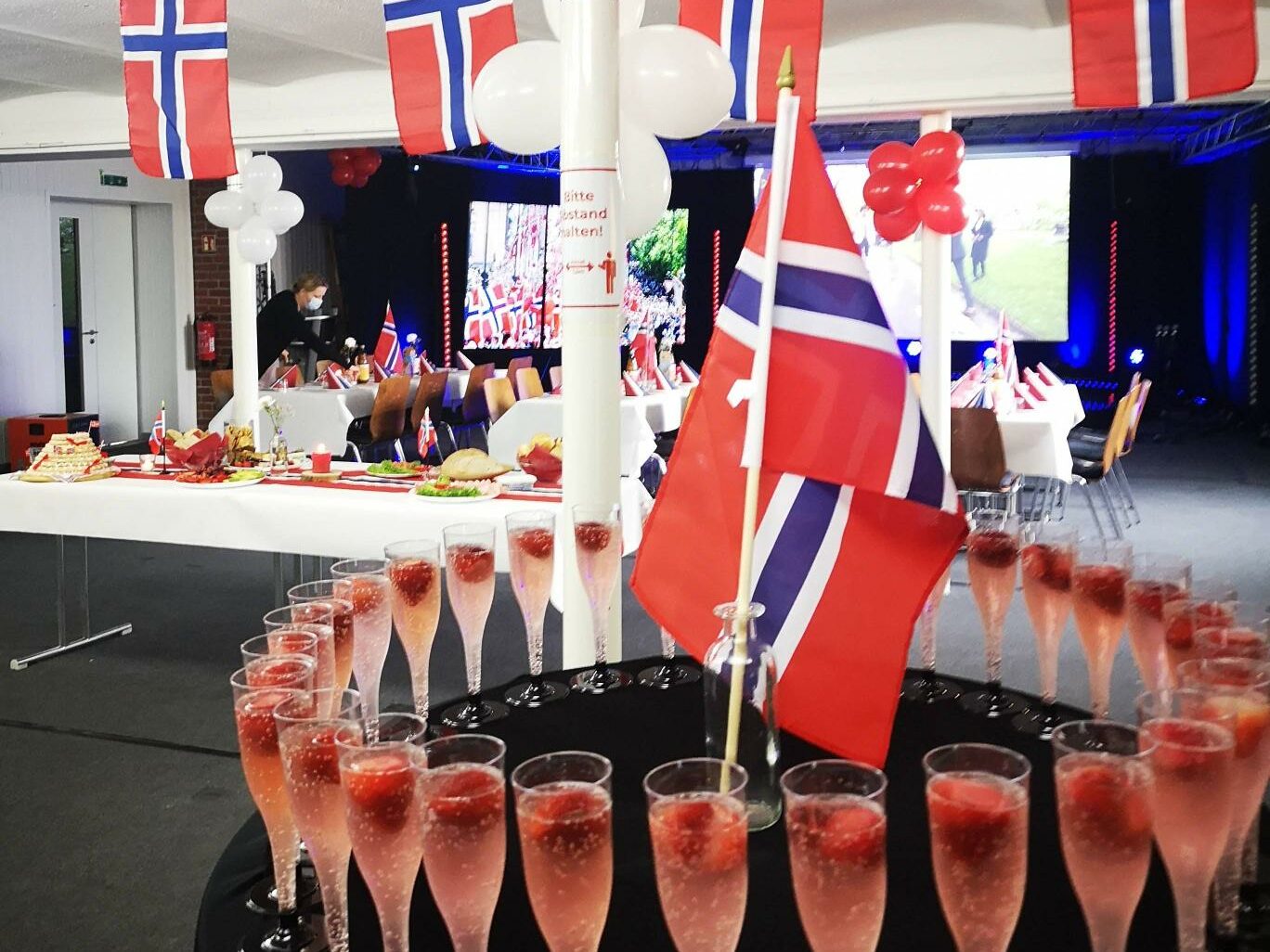 Nasjonaldagen markeres med norske flagg, mat og Norges nasjonalsang synges på norsk.